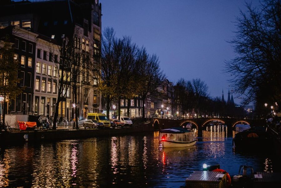 Amsterdam: Private Romantic Evening Boat Tour with Prosecco - Amsterdam after dark, seen from the water