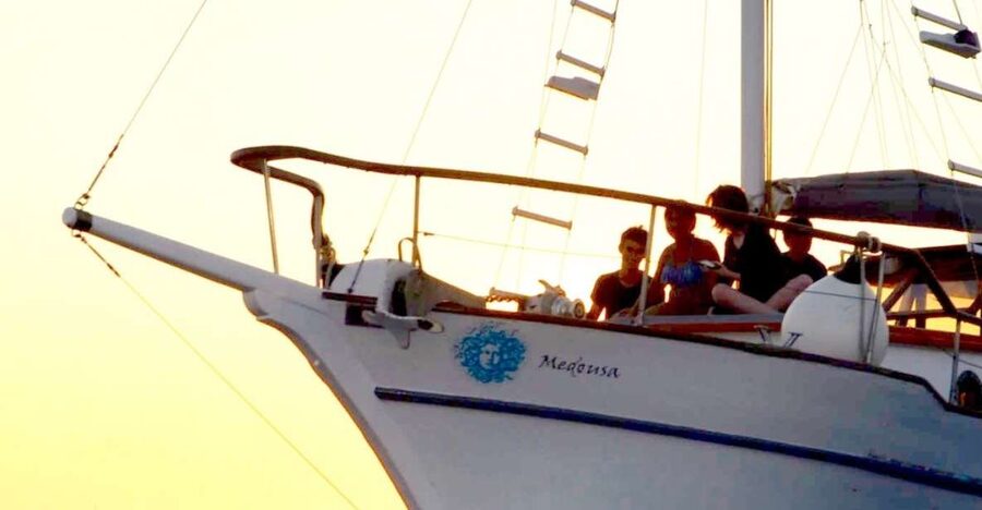 Santorini: Traditional Wooden Boat Tour with Meal and Wine - Passing Akrotiri Lighthouse and entering the caldera