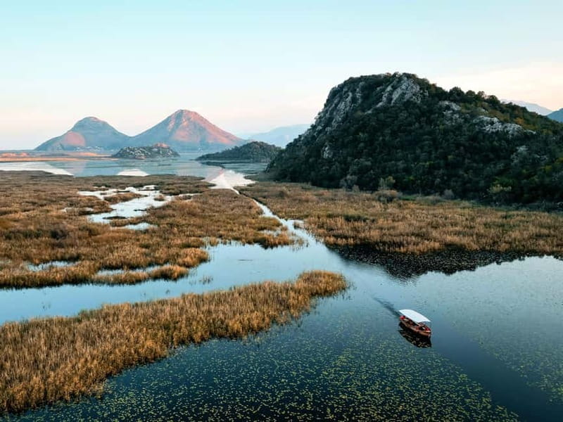 Skadar Lake: Guided Sunset Boat Tour with Wooden Boat & Wine - Kamenik brings wine, a photograph, and a pause